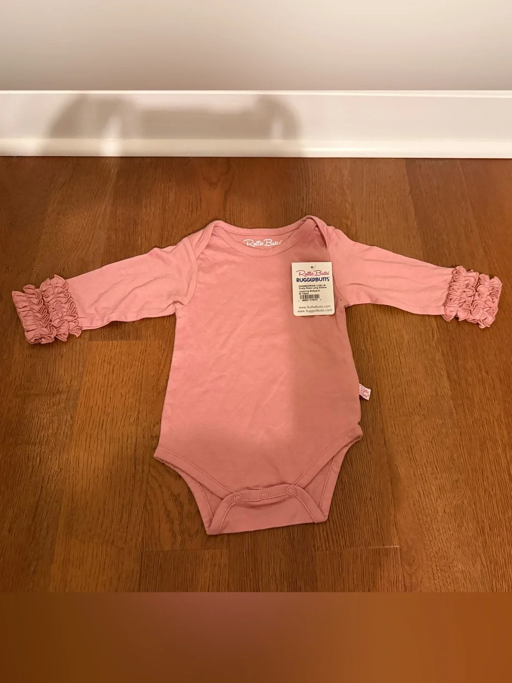 NWT RuffleButts Dusty Rose Ruffle Sleeve Bodysuit 6-12M Flaw